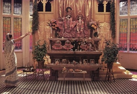 Women Hare Krishna devotee offering Aroti to the Deities Sri Sri Radha Gokulananda at Bhaktivedanta Manor Lechmore Heath Watford England 1973.