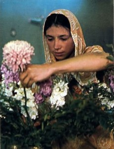 Woman Hare Krishna devotee arranging flowers for Krishna
