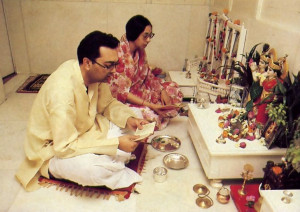 Ceremonies before the Deity of Krsna and readings from Bhagavad-gita bring Nathji and his wife Maithili to the family temple room each morning and evening. Articles for the traditional arati fill the altar: flower, conchshell, andkerchief. essential oils. incense. ghee wick lamps, and water cup.