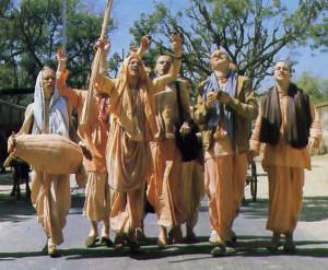 His Holiness Siva-rama Swami (holding staff) leads devotees in chanting Hare Krsna along Bbaktivedanta Road, which runs past the temple.