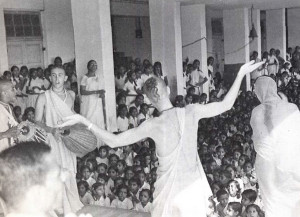 Srila Prabhupada holds lecture and chanting before a large school assembly.