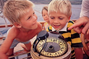 Children receive an impromptu lesson about the ship's compass during a Saturday cruise