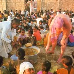 Hare Krishna devotees distributing prasadam (food) to the hungry at ISKCON Mayapur, West Bengal, India. 1974.