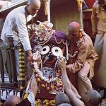 Devotees lift Lord Krishna, in His form as Lord Jagannatha, to His place on His float. San Fransisco, 1975.