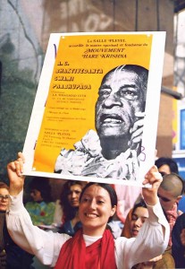 A blissful devotee on a Paris street advertises Srila Prabhupada's forthcoming lecture. 1975.