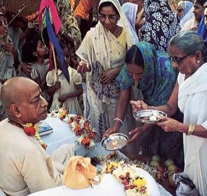 Showing respect in an ancient way, ISKCON life members offer lamps at Srila Prabhupada's feet. 1975. Bombay.