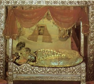 Taking rest in the Mirror Temple, little Deity of Krishna lies on soft bedding. Vrindavan 1975.