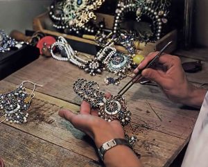 Hare Krishna devotee making jewelery for Radha Krishna deities. 1976.