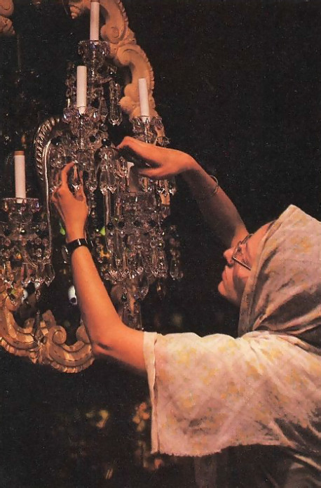 A crystal sconce gets finishing touches from Isani-devi dasi , who designed forty sconces and chandeliers for the Palace. 