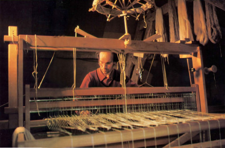 Immersed in working his loom, Bhakta Claude, a devotee artisan at the Krsna conscious farm in Valencay, France. prepares cloth from hand· spun wool.