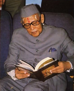 Gov. Chandreswar Singh looks through one of the books of the Krsna consciousness movement.