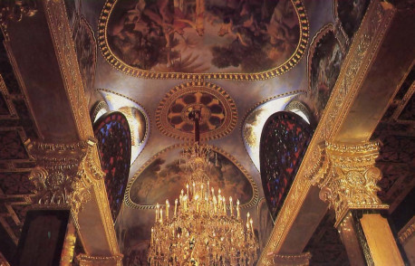 An antique French chandelier lights the ceiling of the main hall of worship. The large mural partially obscured by the chandelier depicts Lord Krsna dancing with the cowherd damsels of Vrndavana. The other large mural shows Lord Caitanya, an incarnation of Krsna, chanting the Hare Krsna mantra and dancing with His dose associates.