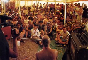 Festival-goers sit in rapt attention as Dhmadyumna Swami explains karma and reincarnation during a break between songs.