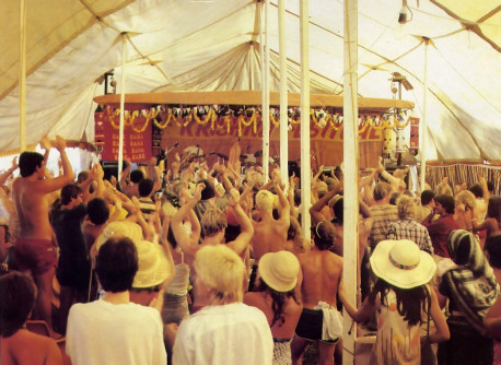 The crowd rises to its feet as the band pumps out a rhythmic rendition of the Hare Krsna mantra
