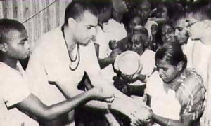 A Bengali devotee eagerly receives chippedrice-with-yogurt from His Holiness Satadhanya Swami.