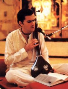 Nandikesvara dasa, leader of the Montreal center, play a traditional Indian tamboura as he sings the glories of Lord Krsna.