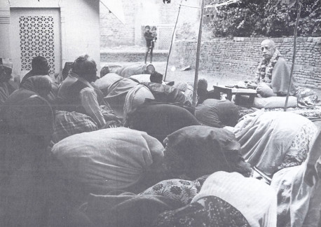 In the courtyard of Radha-Damodara: Devotees offer obeisances as Srila Prabhupada concludes chanting and begins to speak. On the left is the samadhi of Srila Rupa Gosvami.